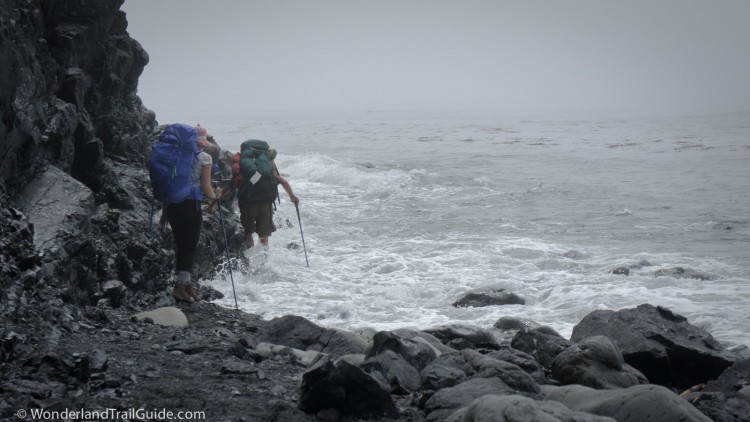 Hikers struggle around an outcrop on the Lost Coast Trail