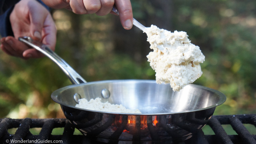 Dropping a lump of biscuit dough into the frying pan