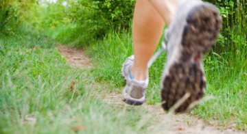 Running woman on trail in forest, motion blur